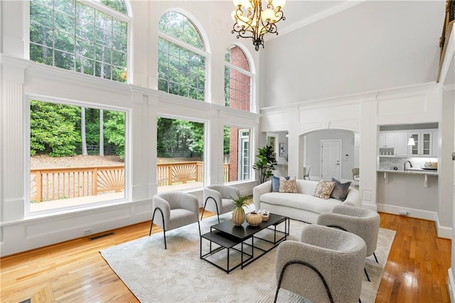 130 Robin Rd, Marietta, GA 30067 - living room featuring a high ceiling, arched walkways, light wood-style floors, and a chandelier