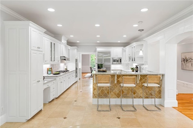 130 Robin Rd, Marietta, GA 30067 - kitchen featuring built in appliances, a peninsula, glass insert cabinets, tasteful backsplash, and ornamental molding