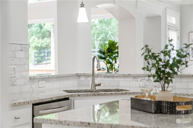 130 Robin Rd, Marietta, GA 30067 - kitchen view of dishwasher, a sink, decorative backsplash, white cabinetry, and light stone counters