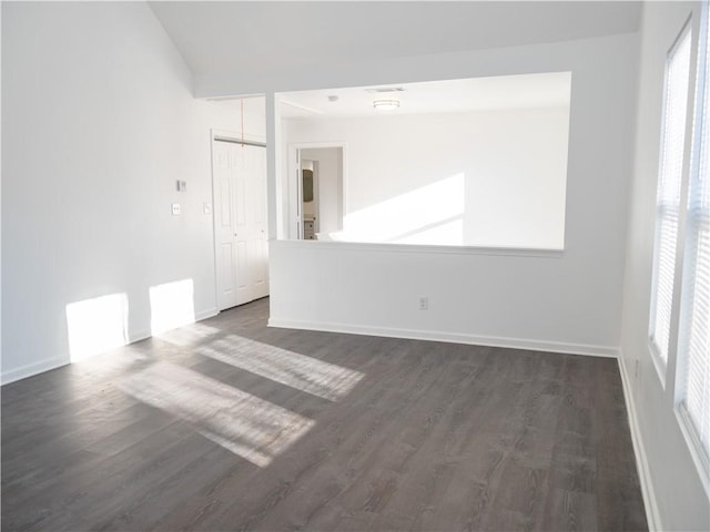 empty room with lofted ceiling and dark wood-type flooring