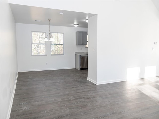 unfurnished living room with a chandelier and dark hardwood / wood-style flooring