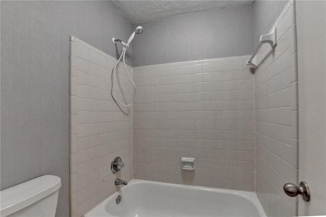 full bathroom featuring toilet, a textured ceiling, and bathtub / shower combination