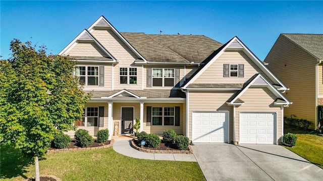 craftsman house with a front yard and a garage