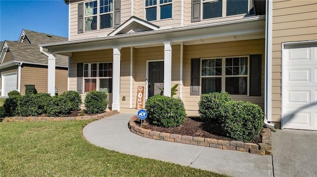 view of exterior entry with a lawn and covered porch