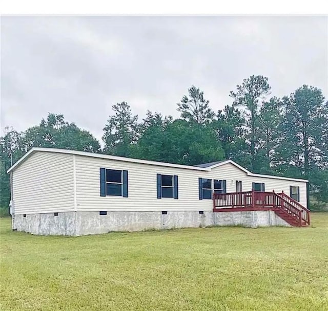 back of property featuring a deck and a yard