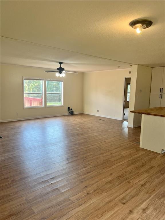 spare room featuring light hardwood / wood-style floors, a textured ceiling, and ceiling fan