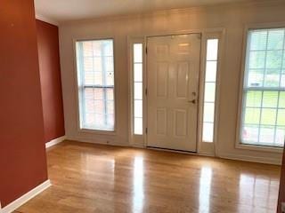 foyer entrance with wood finished floors and baseboards