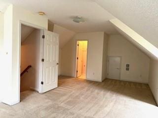 bonus room with light carpet and lofted ceiling