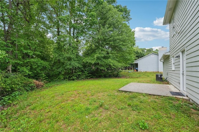view of yard featuring central air condition unit and a patio