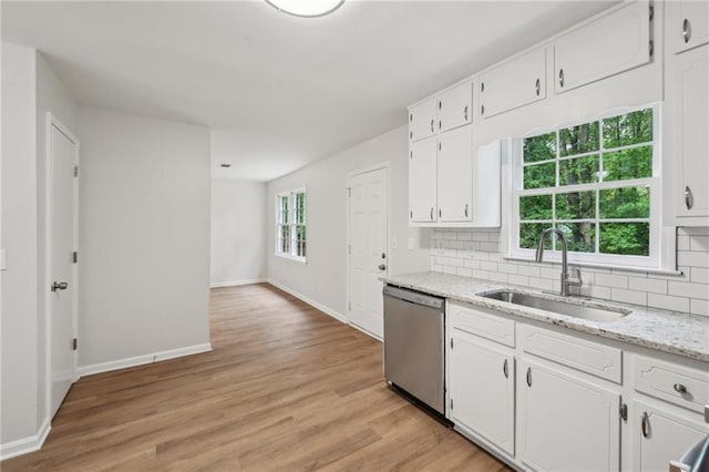 kitchen with a sink, baseboards, white cabinetry, decorative backsplash, and dishwasher