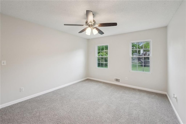empty room with a textured ceiling, ceiling fan, baseboards, carpet flooring, and visible vents