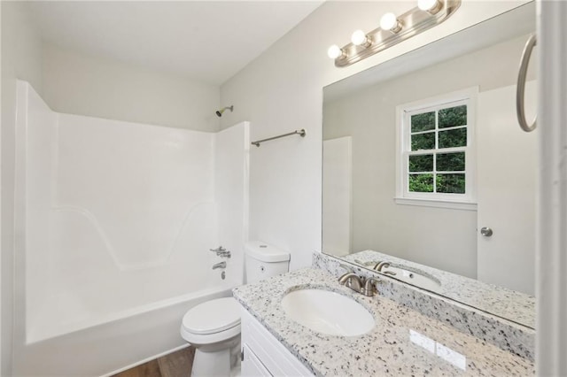 bathroom with wood finished floors, vanity,  shower combination, and toilet
