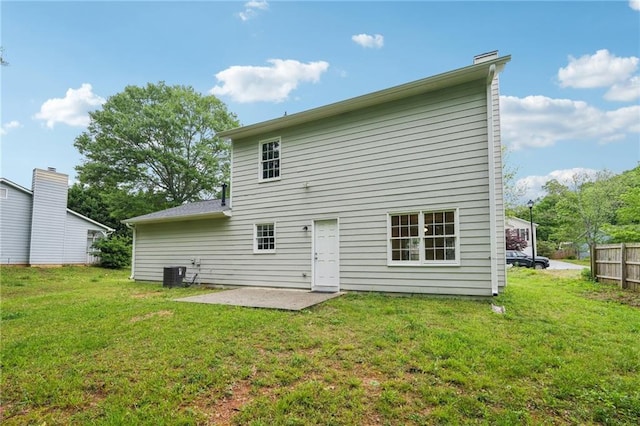 rear view of house with a lawn, central AC unit, fence, and a patio