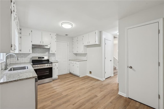kitchen with white cabinets, under cabinet range hood, a sink, decorative backsplash, and stainless steel electric range