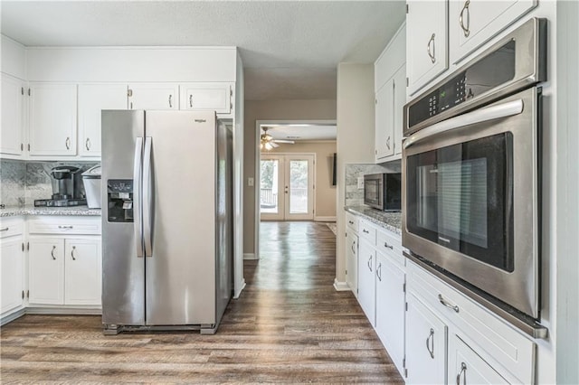 kitchen featuring stainless steel appliances, wood finished floors, ceiling fan, and decorative backsplash