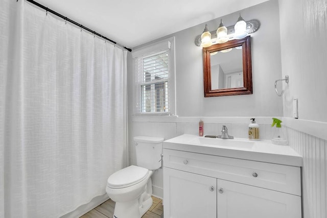 bathroom featuring toilet, walk in shower, and vanity