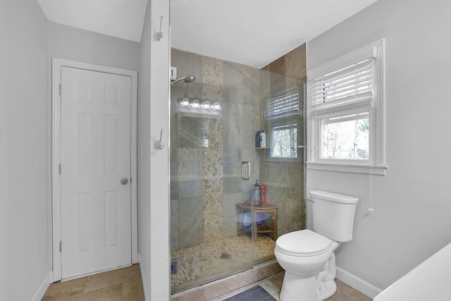 bathroom featuring toilet and an enclosed shower