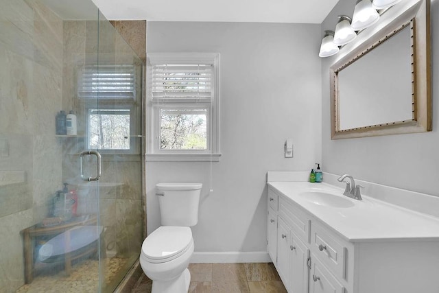 bathroom with vanity, a shower with shower door, and toilet