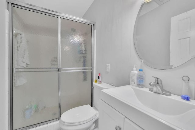 bathroom featuring toilet, an enclosed shower, and vanity