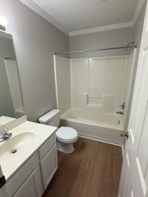 363 Mount Vernon Dr, Calhoun, GA 30701 - bathroom featuring a textured ceiling, toilet, wood finished floors, vanity, and bathtub / shower combination