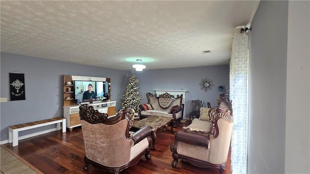 living room featuring dark hardwood / wood-style flooring and a textured ceiling