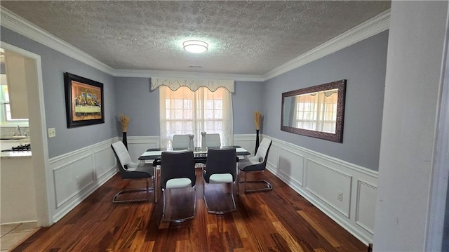 dining space featuring sink, ornamental molding, dark hardwood / wood-style floors, and a textured ceiling