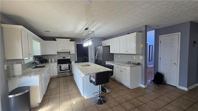 kitchen featuring white cabinetry, appliances with stainless steel finishes, and a center island