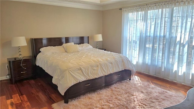 bedroom with crown molding and dark hardwood / wood-style floors