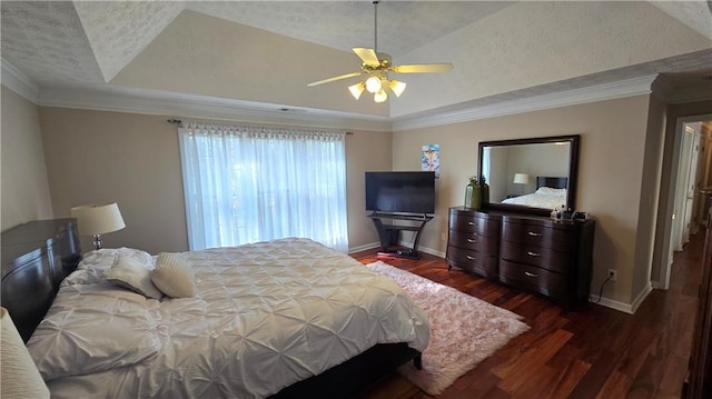 bedroom featuring a raised ceiling, crown molding, dark wood-type flooring, and ceiling fan