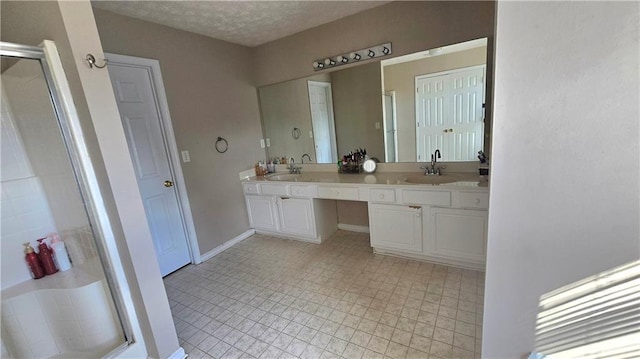 bathroom featuring vanity, an enclosed shower, and a textured ceiling