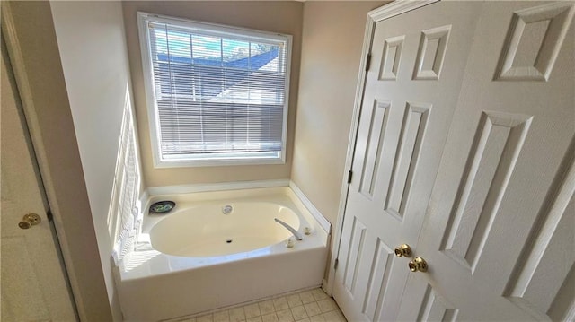 bathroom featuring tile patterned flooring and a tub to relax in