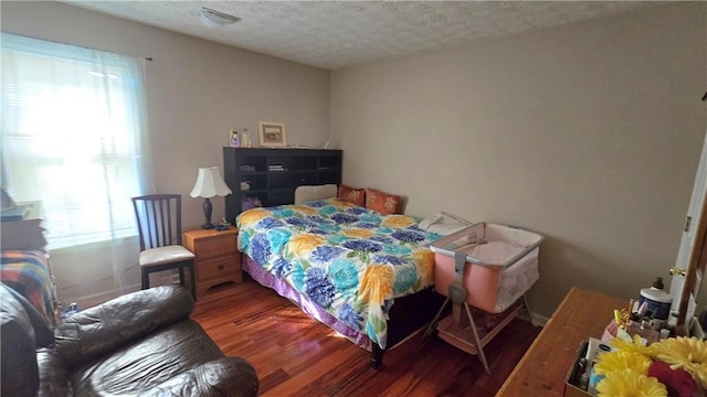 bedroom with hardwood / wood-style flooring and a textured ceiling