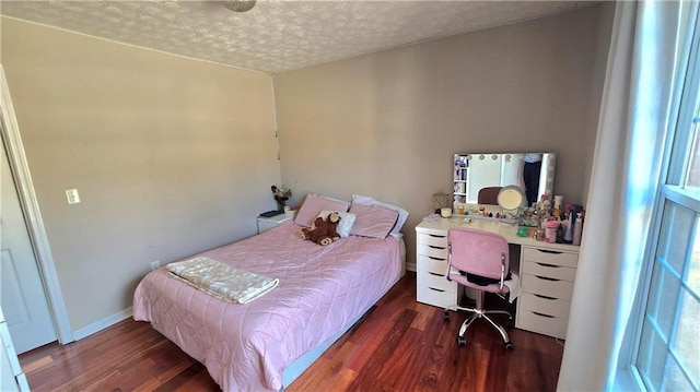 bedroom featuring dark hardwood / wood-style flooring and a textured ceiling