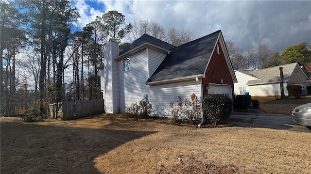 view of side of home featuring a yard and a garage