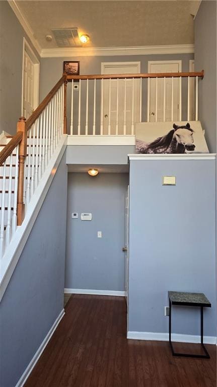 stairs featuring hardwood / wood-style flooring and crown molding