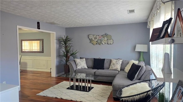 living room featuring dark hardwood / wood-style floors and a textured ceiling