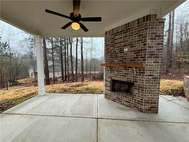 view of patio with an outdoor brick fireplace and ceiling fan