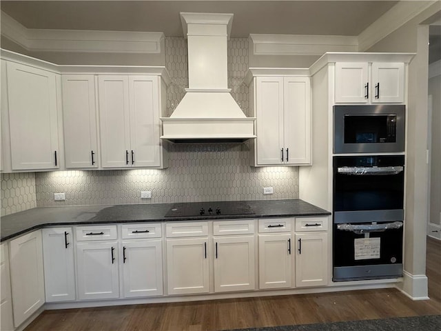 kitchen with custom exhaust hood, white cabinetry, and double oven