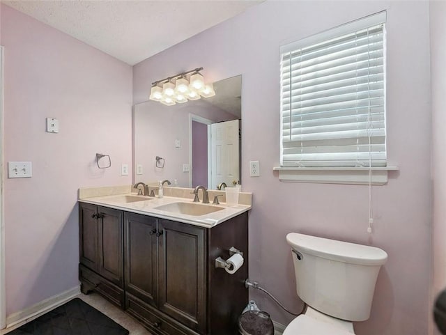 bathroom featuring tile patterned flooring, vanity, a textured ceiling, and toilet