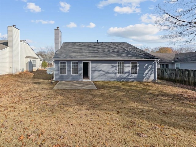 back of property featuring a patio area and a yard