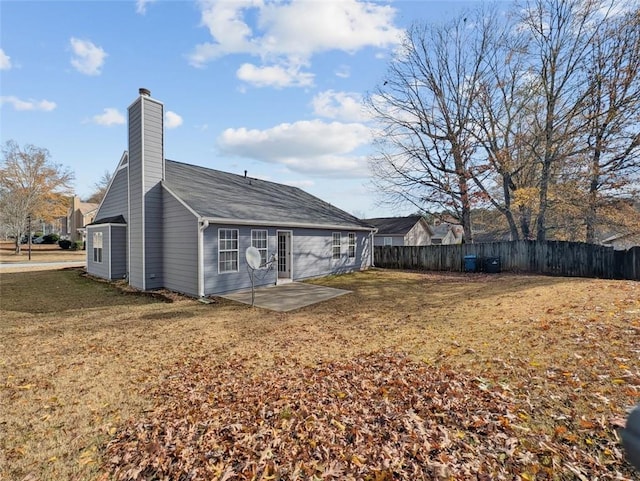 rear view of house featuring a patio and a lawn