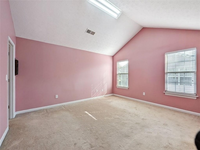 carpeted empty room featuring lofted ceiling