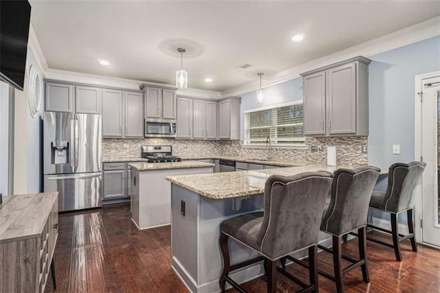 kitchen featuring a peninsula, stainless steel appliances, crown molding, and gray cabinetry