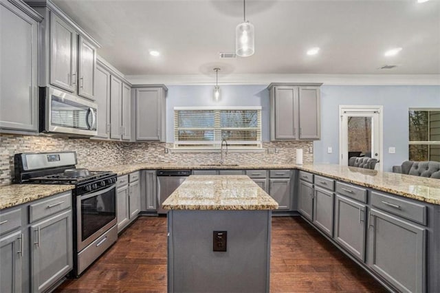 kitchen with a peninsula, stainless steel appliances, gray cabinets, and a sink