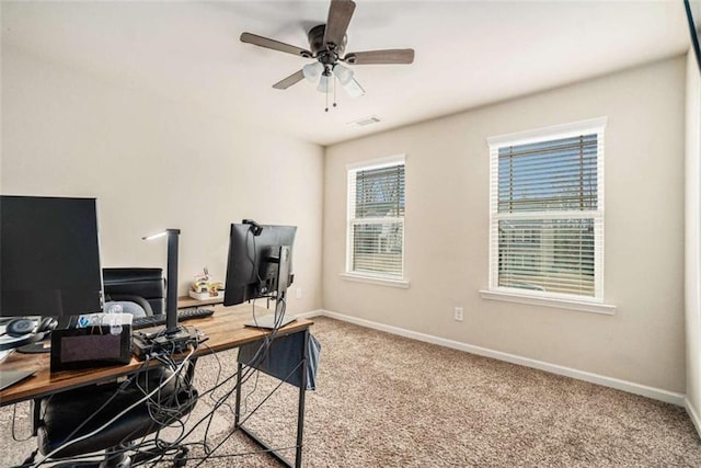 office space featuring a ceiling fan, light carpet, visible vents, and baseboards