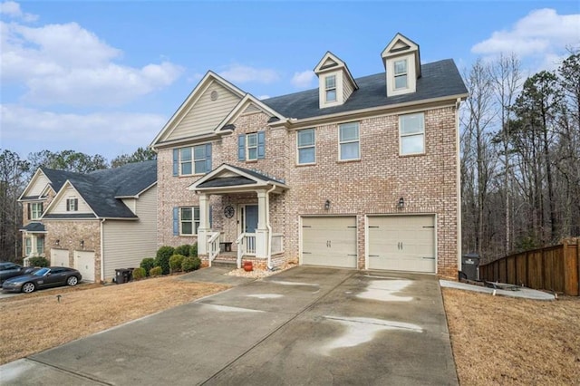 view of front of property with driveway, a garage, fence, and brick siding