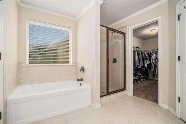 full bathroom featuring a walk in closet, crown molding, tile patterned floors, a shower stall, and a bath