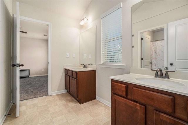 bathroom featuring two vanities, a sink, and baseboards