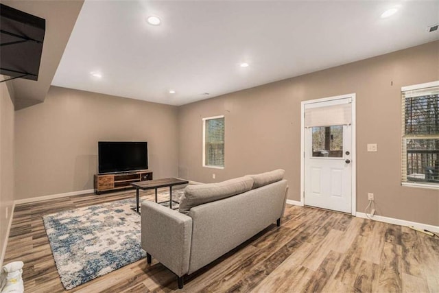 living area featuring recessed lighting, visible vents, baseboards, and wood finished floors