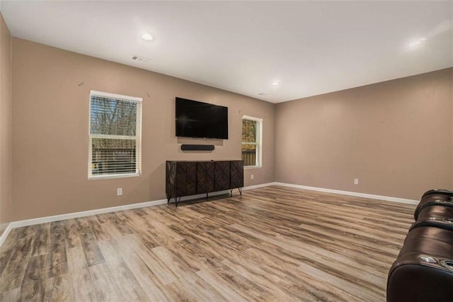 unfurnished living room featuring recessed lighting, wood finished floors, visible vents, and baseboards